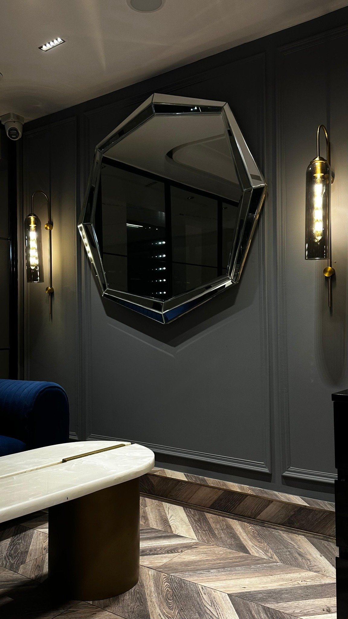 Office lounge detail with a faceted mirror and wall lights