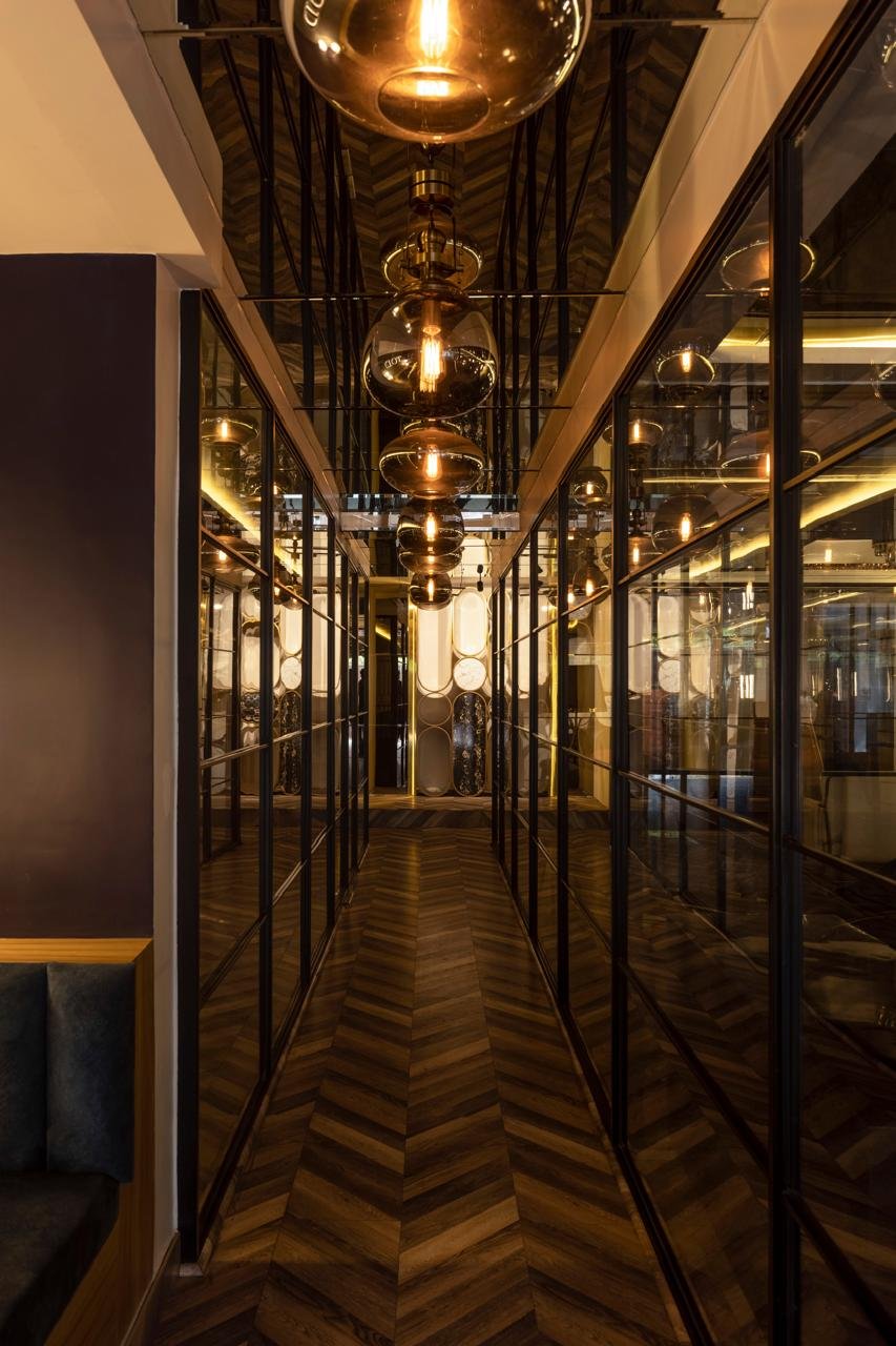 Narrow office passage with gold framing and patterned timber flooring